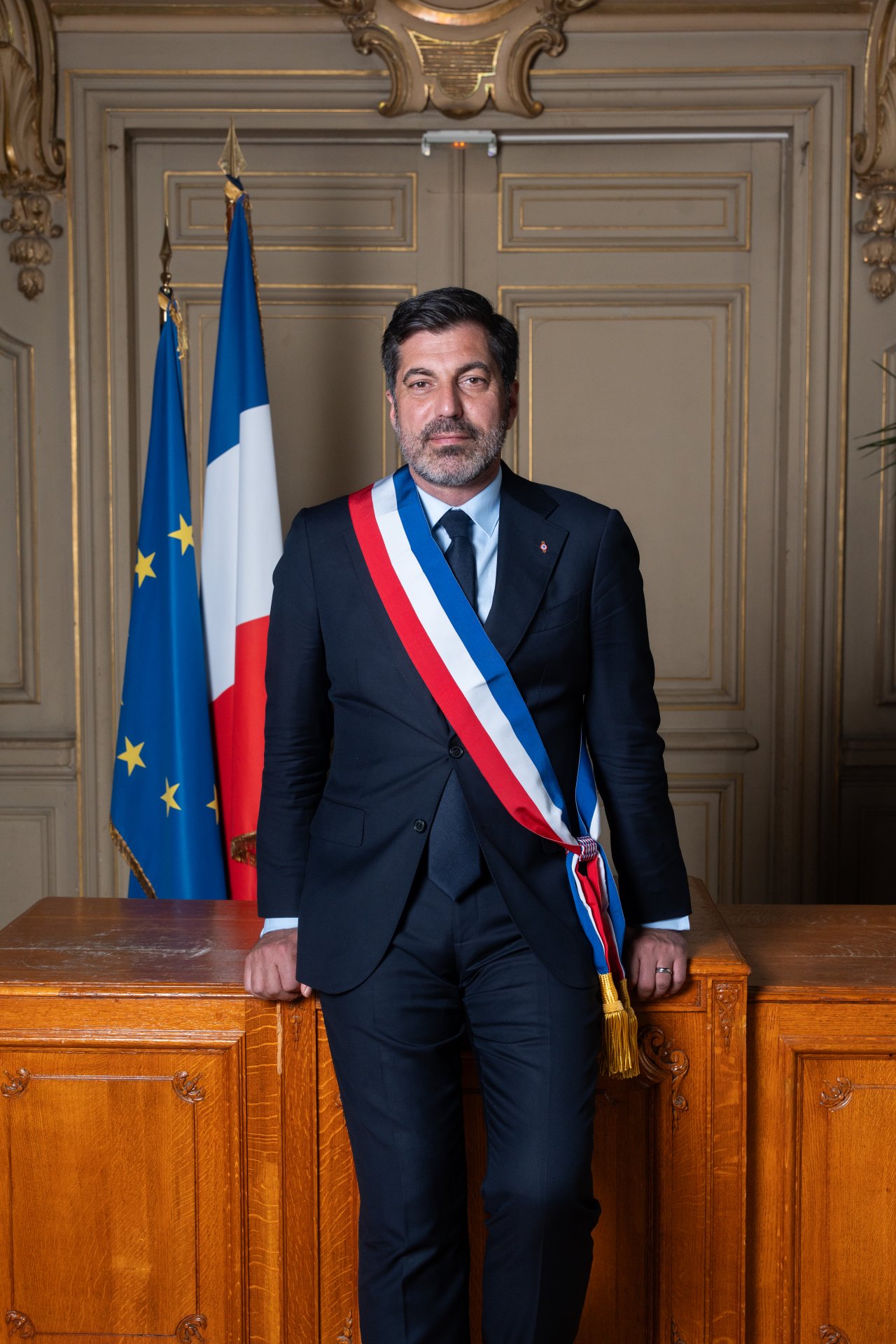 Neuer Bürgermeister der Partnerstadt Colombes steht vor einem Tisch