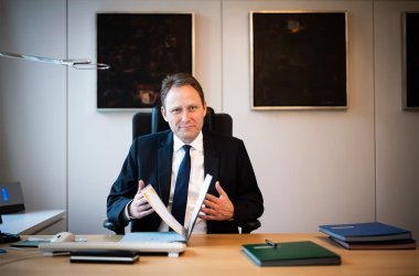 Portrait Martin Hebich am Schreibtisch sitzend