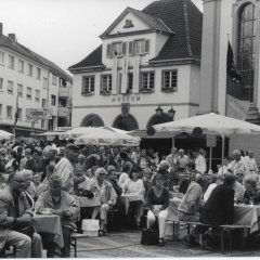 Viele Menschen auf Bierzeltgarnituren auf dem Rathausplatz