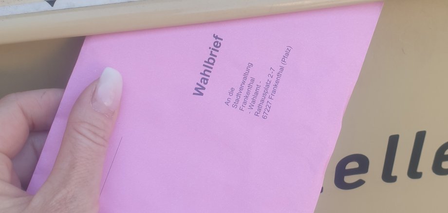 Wahlbrief wird in einen Briefkasten geworfen