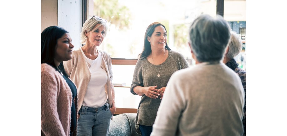 Auf dem Bild sind 5 Frauen zu sehen, die im Gespräch sind.