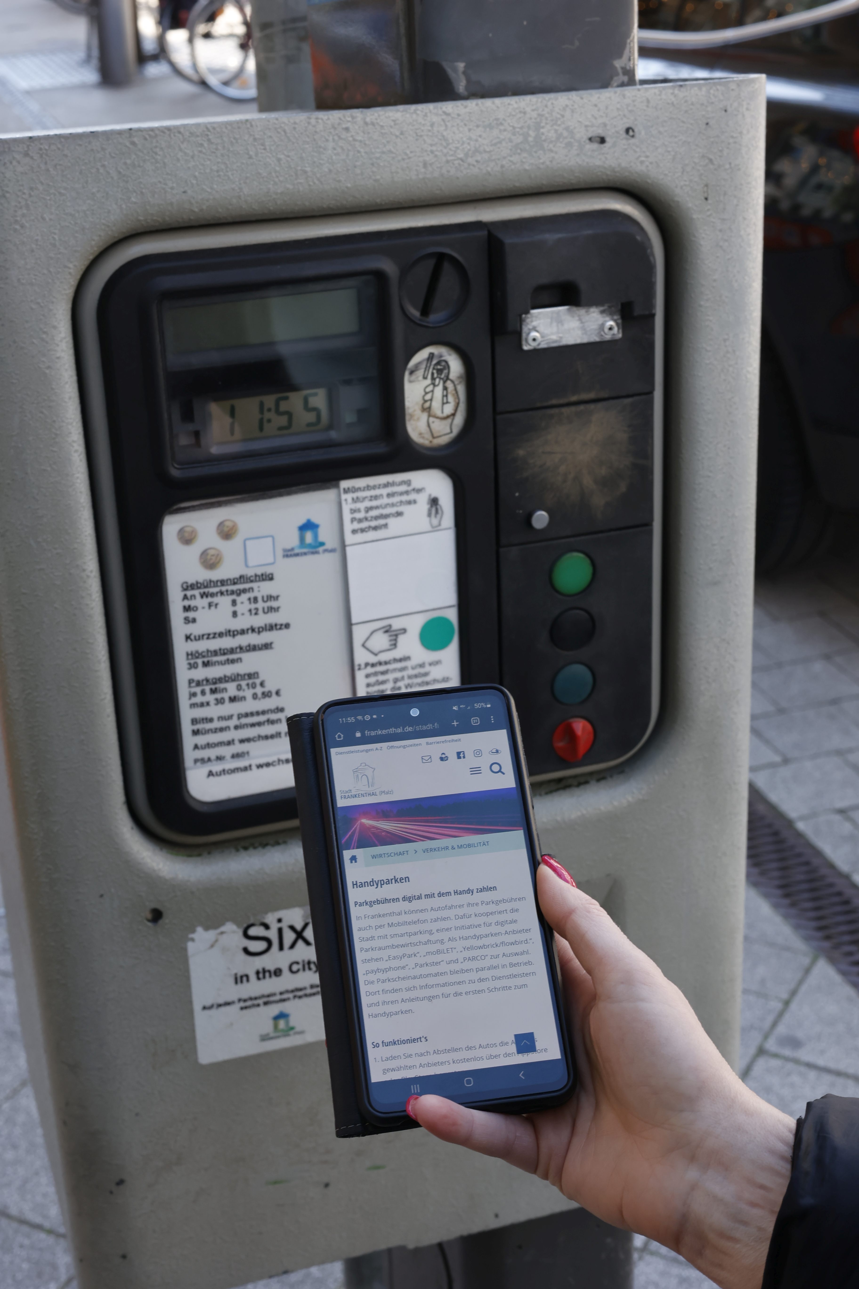 Handy vor Parkscheinautomat