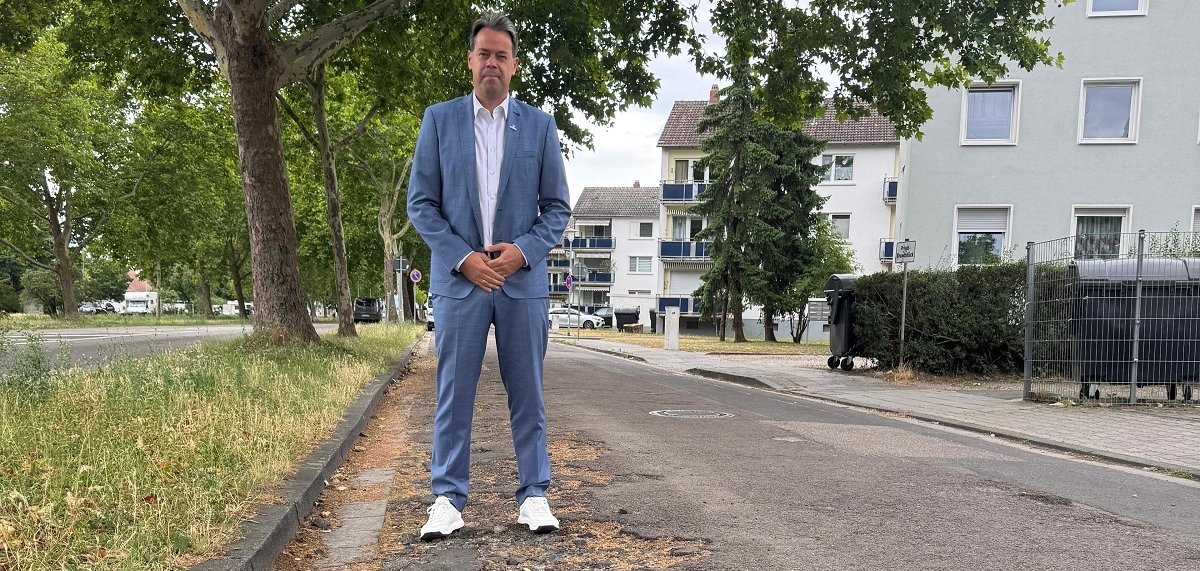 Mann im Anzug steht auf kaputter Straße