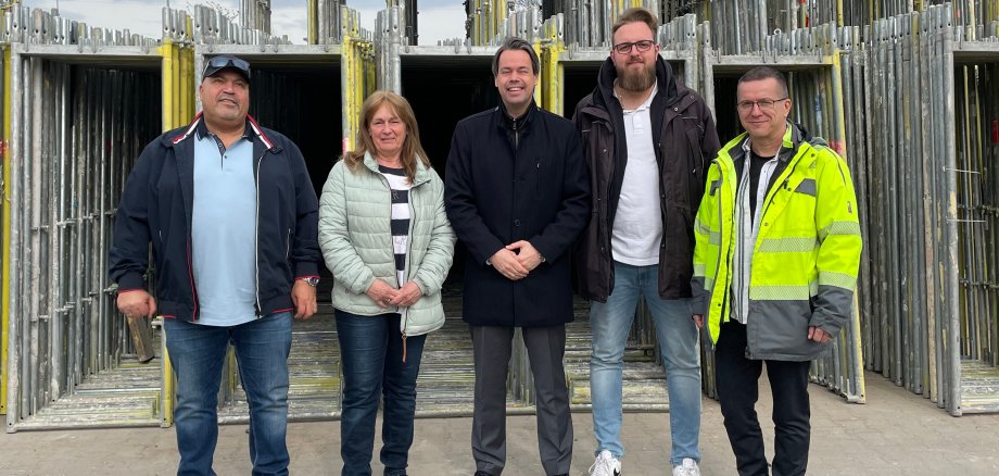 Gruppenfoto, vier Personen auf einem Betriebsgelände