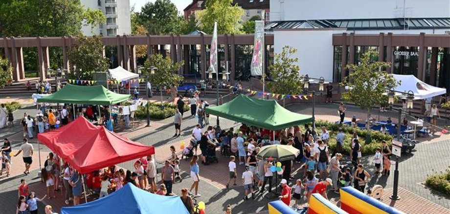 Kinderstadt Blick auf Kinderfest von oben mit bunten Pavillons und einer Hüpfburg an der Seite