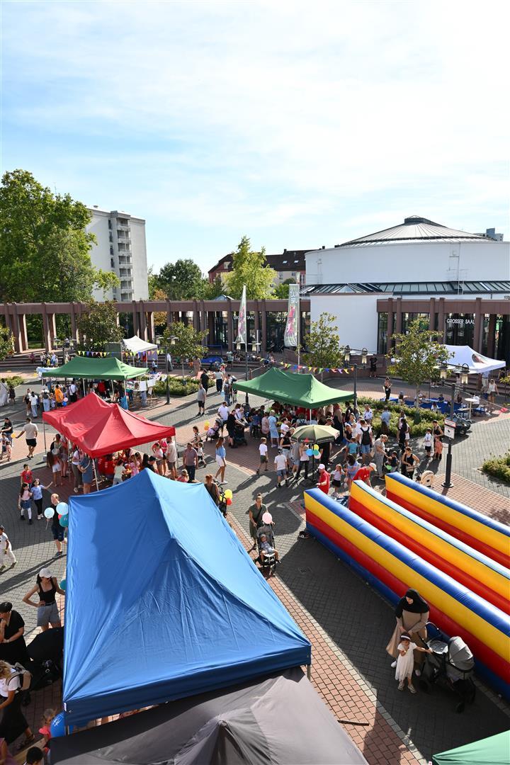 Blick auf Kinderfest von oben mit bunten Pavillons und einer Hüpfburg an der Seite