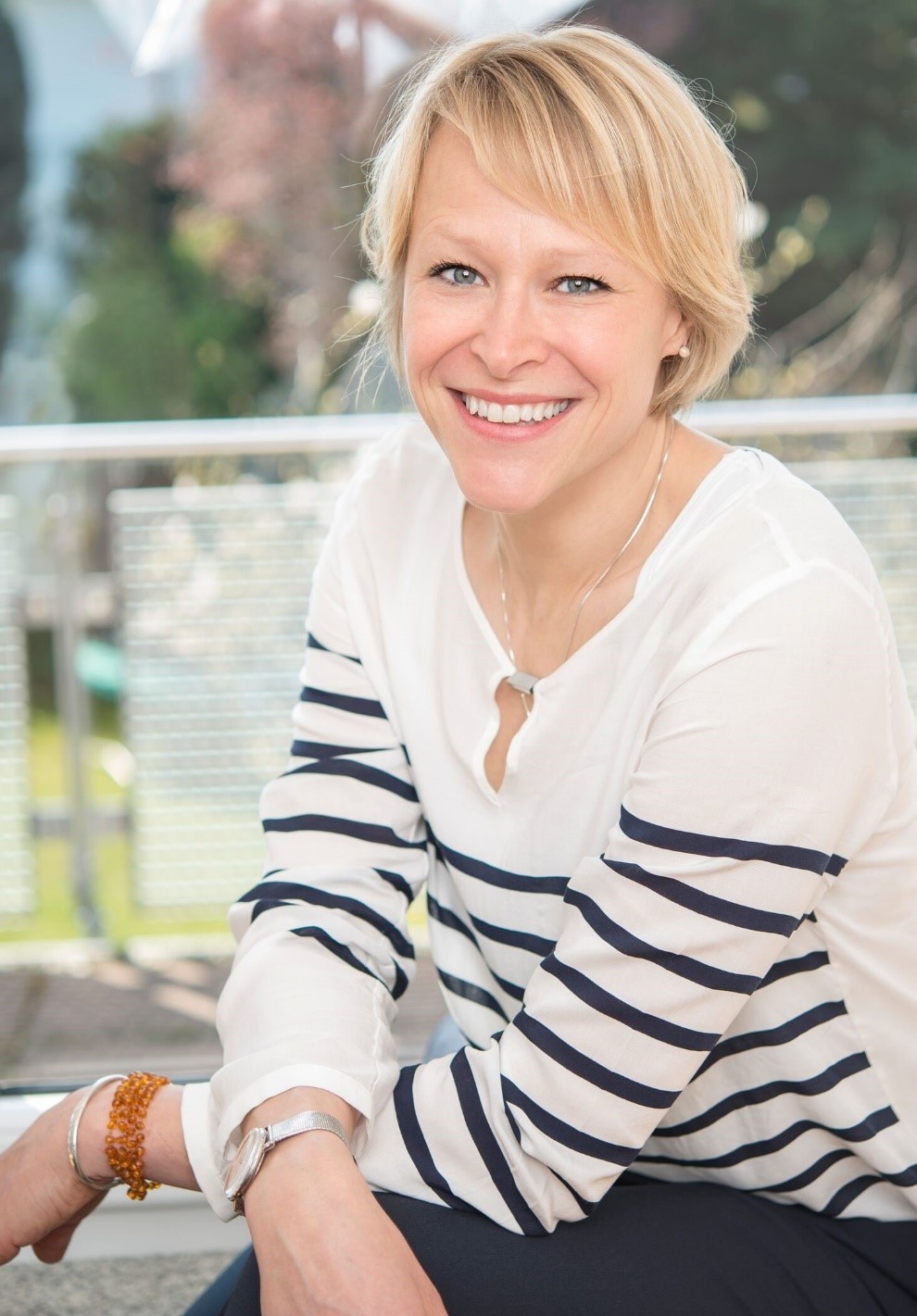 Ulrike Piske Blonde, lächelnde Frau mit schwarz-weißem Pullover