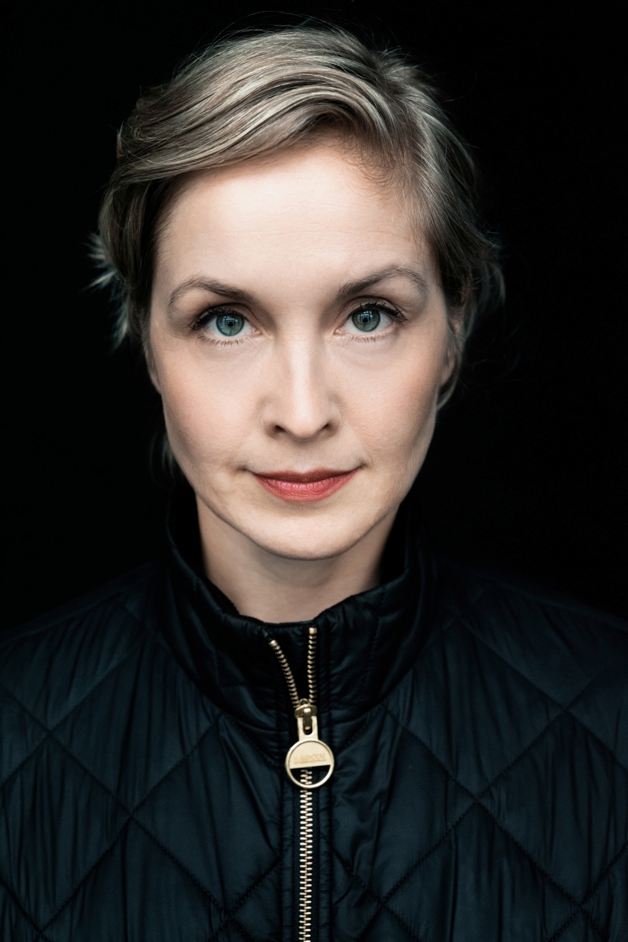 Coverfoto Valery Tscheplanowa Es ist ein Coverbild von einer Frau mit hellgrauen Haaren zu sehen. Es handelt sich um die Autorin Valery Tscheplanowa. Die Autorin hat auf dem Bild einen ernsten Blick und schaut frontal in die Kamera. Sie trägt eine schwarze Jacke mit goldenem Reißverschluss.