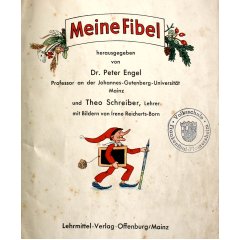 Objekt des Monats 2023 - Ansicht Deckblatt Innen. Darauf: Titel "Meine Fibel" im Banner mit Pflanzenillustrationen, Illustration einer Kasperle-Figur mit Schreibtafel unter dem Arm und übergroßem Bleistift als Spazierstock, Stempel der Volksschule Frankenthal-Flomersheim. Weiterer Text: "herausgegeben von Dr. Peter Engel, Professor an der Johannes-Gutenberg-Universität Mainz und Theo Schreiber, Lehrer, mit Bildern von Irene Reicherts-Born. Lehrmittelverlag Verlag Offenburg/Mainz"