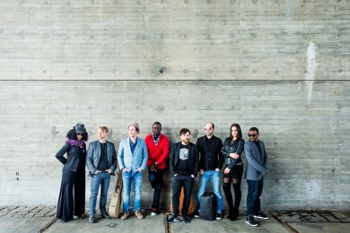 shebeen Gruppe Menschen vor grauer Wand
