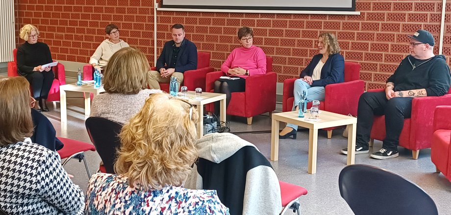 Auf dem Bild ist eine Talkrunde von Frauen und Männern sitzend zu sehen 