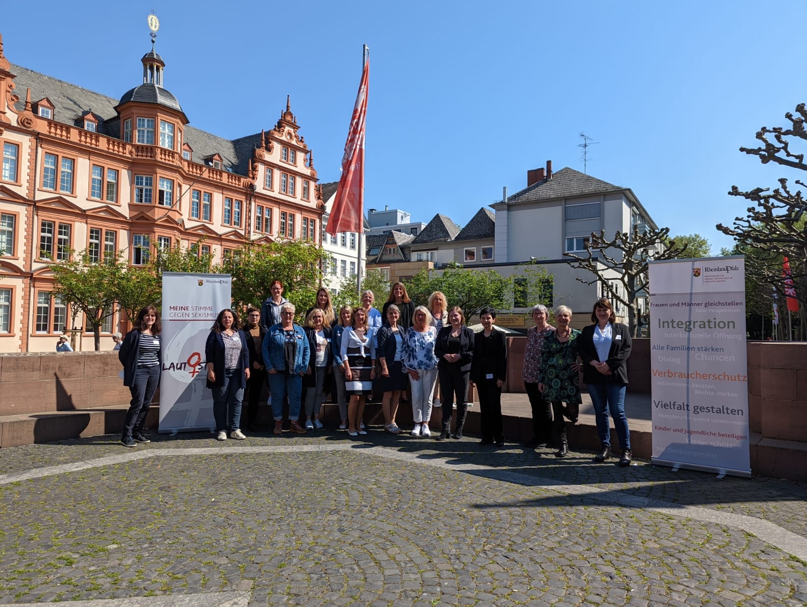 Die Frauenministerin Katharina Binz  steht umgeben mit den kommunalen Gleichstellungsbeauftragten auf dem Platz. 