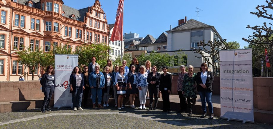 Die Frauenministerin Katharina Binz  steht umgeben mit den kommunalen Gleichstellungsbeauftragten auf dem Platz. 