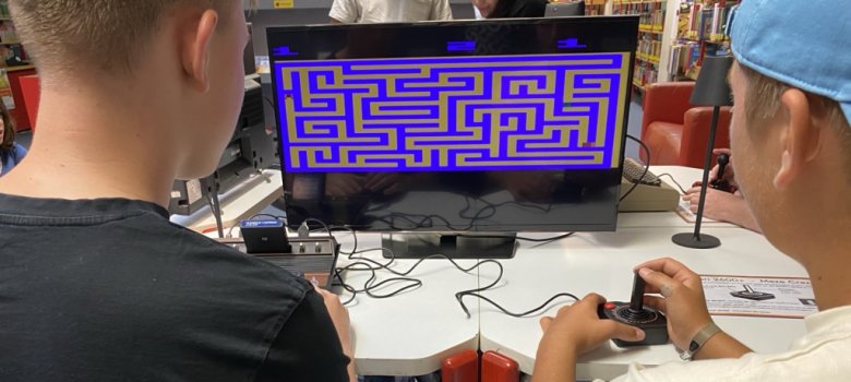 Retrogaming in der Stadtbücherei Blick über die Schulter zweier Jugendlicher, die an einer Retrokonsole spielen, auf einen Bildschirm.