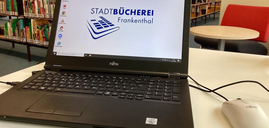 Ein aufgeklappter Laptop steht auf einem Tisch.