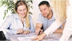 KfW Eine Frau und ein Mann sitzen beratend am Tisch.